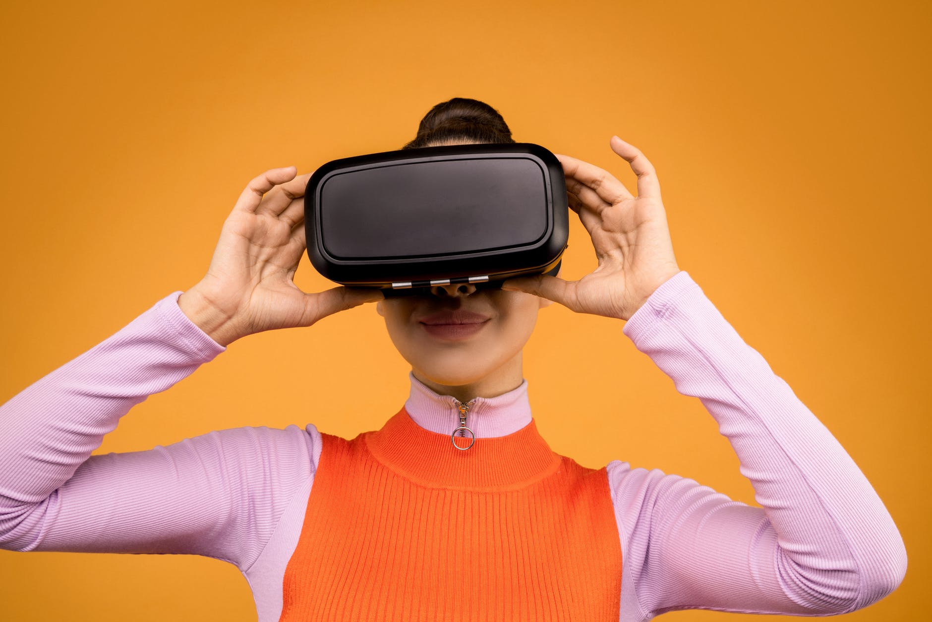Imagen de una mujer joven ajustándose sobre el rostro unas gafas de realidad virtual.