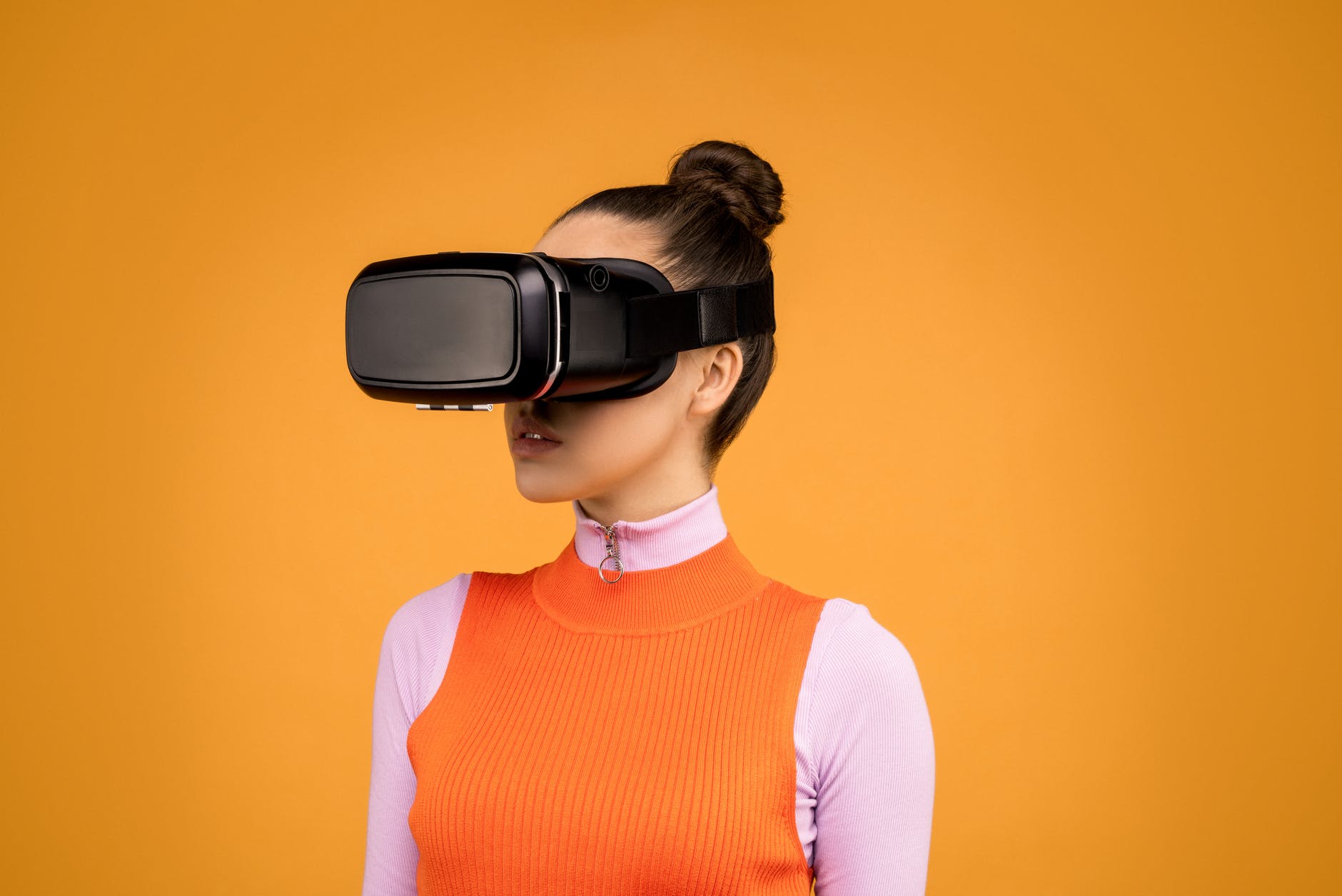 Imagen de una mujer joven utilizando unas gafas de realidad virtual, en esta ocasión no realiza ningún movimiento con las manos.